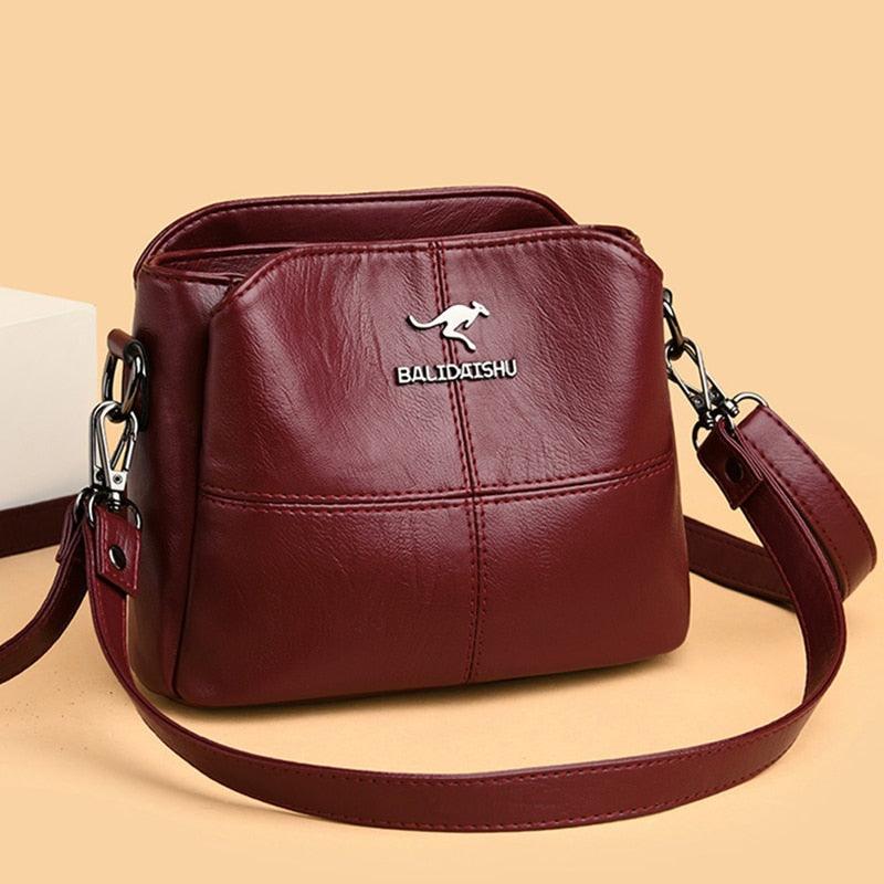 Bolsa Leisure em tom vinho com alça longa, vista de frente.