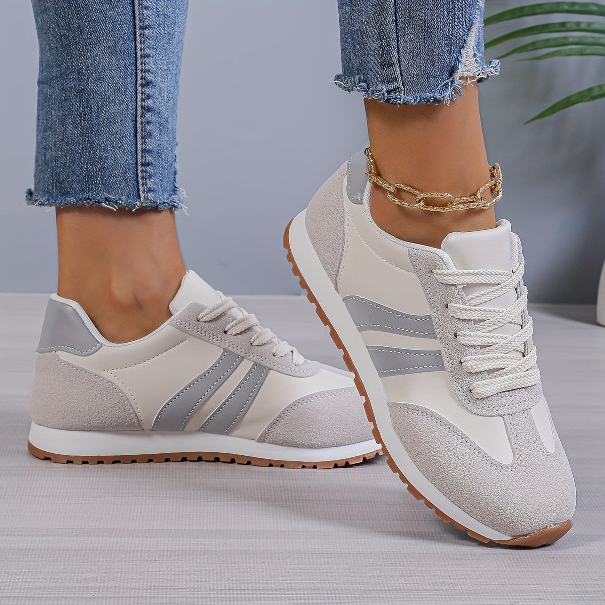 Mulher usando tênis cinza com jeans, detalhe frontal e lateral