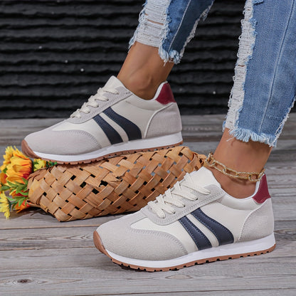 Mulher usando tênis de base clara com faixas marinho e jeans, vista lateral